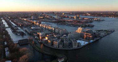 Amsterdam 'ın doğusundaki Cruqius, Hollanda' daki modern yerleşim yerlerinin havadan görünüşü. Altın saat günbatımında.