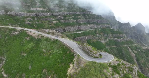 Μαδέρα, ορεινός δρόμος μέσα από τα σύννεφα με βράχια και όμορφη φύση που περιβάλλεται από μια ηλιόλουστη ομιχλώδη ημέρα στην Πορτογαλία. — Αρχείο Βίντεο
