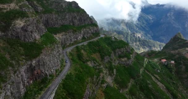 Ilha da Madeira, estrada de montanha através das nuvens com falésias e belíssima natureza rodeada por um dia ensolarado de neblina em Portugal. — Vídeo de Stock