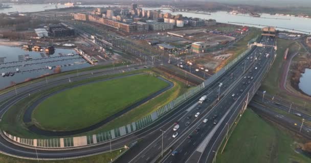 Nizozemská dálnice a křižovatka infrastruktury v Zeeburgereilandu v Amsterdamu. Dálnice A10 při západu slunce. Obytná oblast v pozadí. Pohled na město. — Stock video