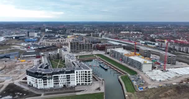 Imágenes aéreas de los modernos departamentos residenciales de Zutphen en construcción, sitio de construcción. El río Ijsel y el IJsselspoorbrug. — Vídeos de Stock
