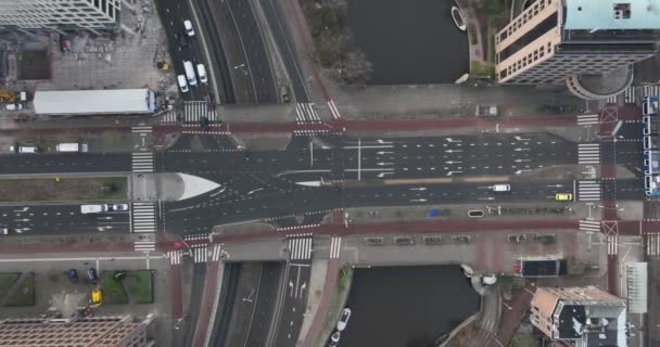 Amsterdam Weesperplein městské letecké drone záběry provozu, auta, tramvaje, chodci, cyklista procházející Wibautstraat, Sarphatistraat a Mauritskade v zimním dni. — Stock video