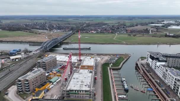 Aerial footage of Zutphen modern residential appartments being build, construction site. The river Ijsel and the IJsselspoorbrug. — стоковое видео