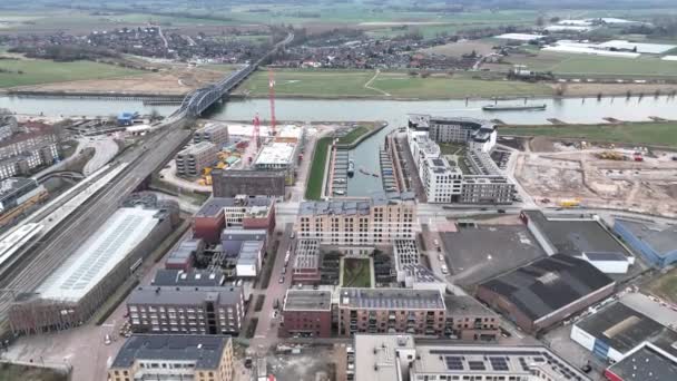 Imágenes aéreas de los modernos departamentos residenciales de Zutphen en construcción, sitio de construcción. El río Ijsel y el IJsselspoorbrug. — Vídeos de Stock