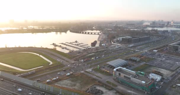 Dutch infrastructure highway and intersection at Zeeburgereiland in Amsterdam. A10 highway at sunset. Residential area in the background. Urban city view. — Stock videók