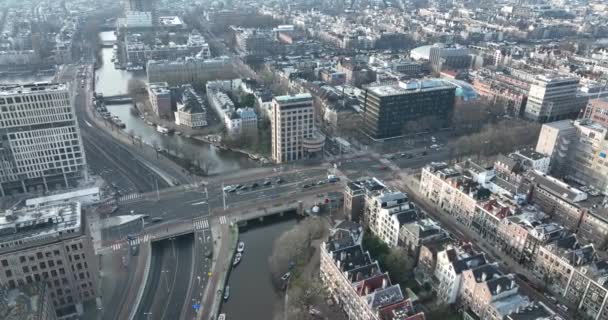 Amsterdam Weesperplein metraje aéreo urbano de aviones no tripulados de tráfico, coches, tranvías, peatones, ciclista pasando por el Wibautstraat, Sarphatistraat y el Mauritskade en un día de invierno. — Vídeos de Stock