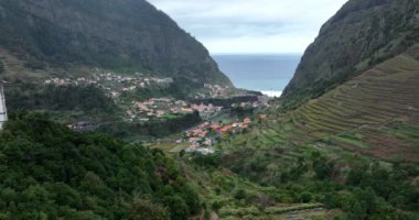 Uçurumlar ve dağlarla çevrili küçük bir kilise ve yeşil doğa manzaralı bir köy. Madeira Portekiz 'de.