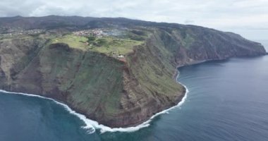 Madeira 'nın kıyı boyunca uzanan küçük deniz feneri, yüksek uçurumlar ve Atlantik Okyanusu boyunca uzanan dağlar..