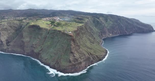 Вид с воздуха на небольшой маяк Мадейры вдоль побережья и высокие скалы и горы вдоль Атлантического океана. — стоковое видео