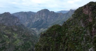 Madeira 'daki dağ antenleri ve uçurumlar bulutlardaki epik yüksek uçurumlar bu güzel doğa manzarasının helikopter görüntüsüyle..