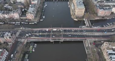 Aerial drone footage of the Amstel river and De Hogesluis Brug 246 in Amsterdam East and city center downtown. Dutch urban infrastructure.