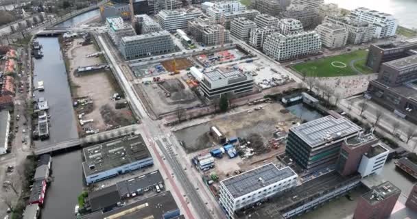 Amsterdam, 1st of January 2022, The Netherlands. Construction site of modern residential real estate apartment buildings at the Buiksloterweg along the Ij in the city center of Amsterdam. — Wideo stockowe