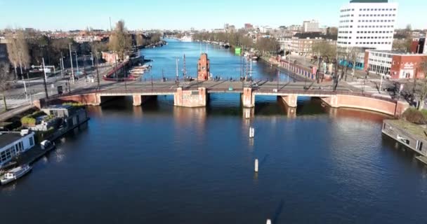 Luchtfoto van de Berlage brug in Amsterdam, Nederland. De Amstel rivier doorkruist de infrastructuur. tram en verkeersknooppunt. Stadsgezicht. — Stockvideo