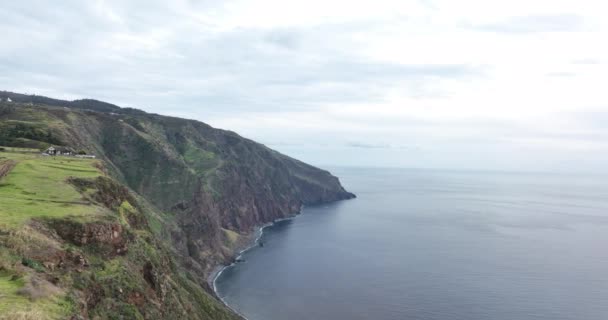 Moutain aéreo y acantilado aéreo de Madeira pequeño faro a lo largo de la costa y altos acantilados y montañas a lo largo del Océano Atlántico. — Vídeo de stock