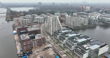 Amsterdam 'ın doğusundaki Cruqius, Hollanda' daki modern yerleşim yerlerinin havadan görünüşü. Altın saat günbatımında.