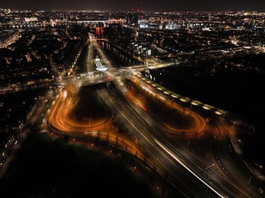Geceleri Amsterdam, Hollanda altyapı yolu kavşağı, tren, yol, raylar, metro ve yayalar. Hava aracı görünümü.