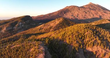 Tenerife 'de, İspanya' da, Avrupa 'da, altın saat batımında bulutların arasında bir dağ ve tepelerin panoramik manzarası..