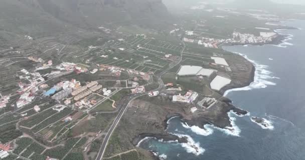 İspanya 'nın Tenerife adasındaki deniz ve kıyı boyunca uzanan küçük bir köyün havadan görünüşü. Tepe tepeleri kayalıkları manzarası. — Stok video