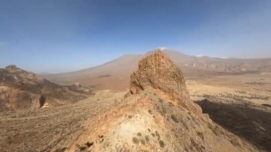 Çölde bir FPV insansız hava aracıyla kayalık ve kumlu bir arazi gibi kayalık bir kaya ve dağ sörfü. Dramatik, kaba doğa parkında yakın uçuş..