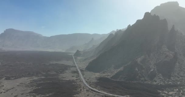 Μεγάλα βράχια σε ένα έρημο αμμώδες τραχύ βραχώδες τοπίο. Δρόμος που διασχίζει το τοπίο Θύελλα σκόνης της ερήμου Calima πάνω από το βουνό στο εθνικό πάρκο της Τενερίφη, Ισπανία, Ευρώπη, Κανάρια Νησιά. — Αρχείο Βίντεο