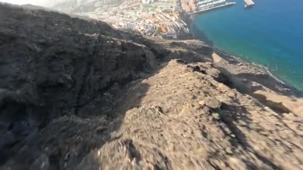 FPV letecký klip strmých skalnatých útesů, které se potápějí po skalách, kamenech a balvanech v drsné mořské krajině na slunné destinaci podél Atlantského oceánu v Tenerife, Španělsko, Evropa — Stock video