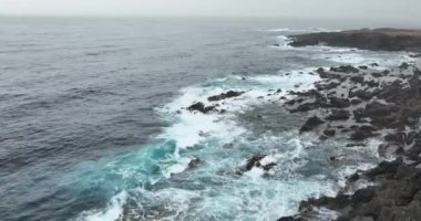 Dalgalı deniz suyu ve kayalık kıyı şeridi. Atalantik okyanus dalgaları ve kıyı boyunca kayalara vuran su. Rahatlatıcı doğa.