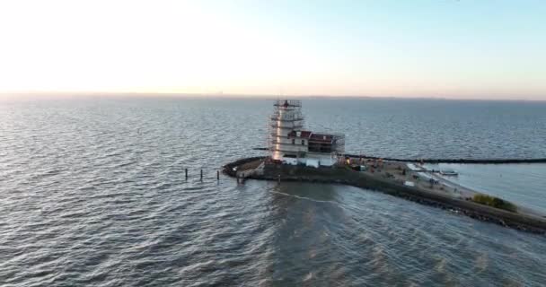 Vue aérienne du phare du monument historique traditionnel Paard van Marken au lever du soleil sur l'île de Marken aux Pays-Bas. Petit village de pêcheurs en Europe. — Video