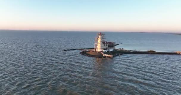 Vue aérienne du phare du monument historique traditionnel Paard van Marken au lever du soleil sur l'île de Marken aux Pays-Bas. Petit village de pêcheurs en Europe. — Video
