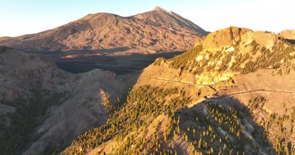 Aérien d'une chaîne de montagnes au coucher du soleil à Tenerife Espagne, île naturelle, arbres collines rochers, falaises et montagnes à l'heure d'or. Europe — Video