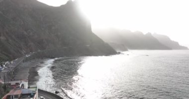 Rocky volkanik plajı yüksek dağlar ve uçurumların insansız hava aracı görüntüsüyle çevrilidir. Tenerife İspanya Canaray adaları Avrupa.