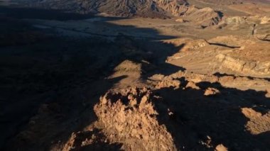 Çölde bir FPV insansız hava aracıyla kayalık ve kumlu bir arazi gibi kayalık bir kaya ve dağ sörfü. Dramatik, kaba doğa parkında yakın uçuş..