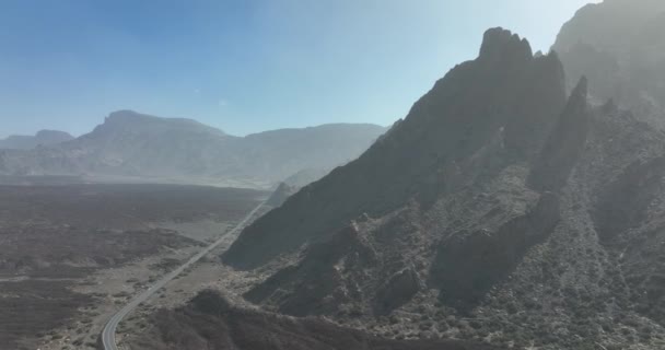 Duże klify w pustynnym, piaszczystym, surowym krajobrazie skalnym. Droga biegnąca przez krajobraz Pustynna burza piaskowa Calima nad górą w Parku Narodowym Teneryfa, Hiszpania, Europa, Wyspy Kanaryjskie. — Wideo stockowe