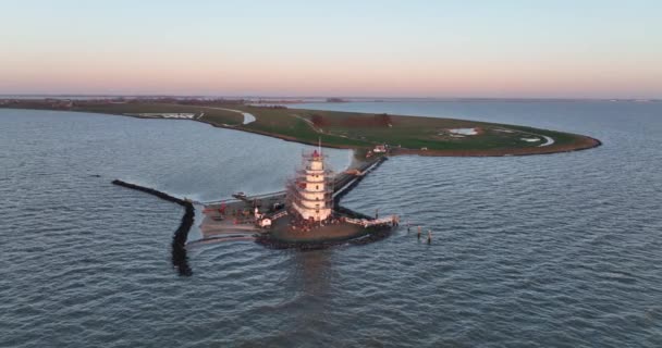 Vista aérea del Paard van Marken al amanecer faro monumento histórico tradicional en la isla de Marken en los Países Bajos. Pequeño pueblo pesquero en Europa. — Vídeos de Stock