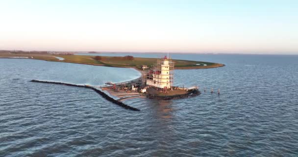 オランダのマーケン島にある日の出の伝統的な歴史的記念碑灯台で、パールファンマルケンの空中ビュー。ヨーロッパの小さな漁村. — ストック動画