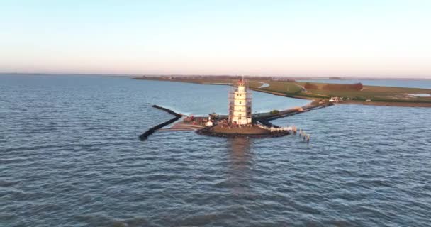 Vista aérea del Paard van Marken al amanecer faro monumento histórico tradicional en la isla de Marken en los Países Bajos. Pequeño pueblo pesquero en Europa. — Vídeos de Stock