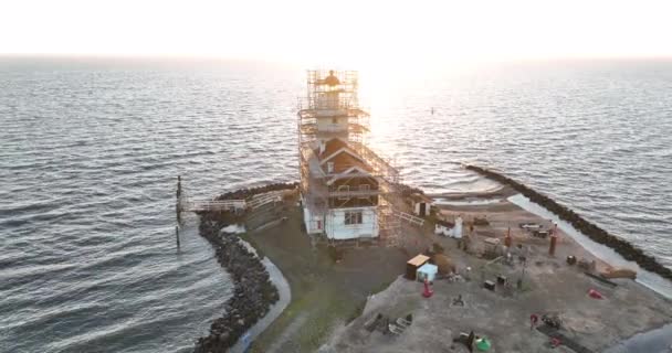 Vista aérea del Paard van Marken al amanecer faro monumento histórico tradicional en la isla de Marken en los Países Bajos. Pequeño pueblo pesquero en Europa. — Vídeos de Stock