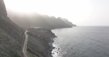 Rocky volkanik plajı yüksek dağlar ve uçurumların insansız hava aracı görüntüsüyle çevrilidir. Tenerife İspanya Canaray adaları Avrupa.