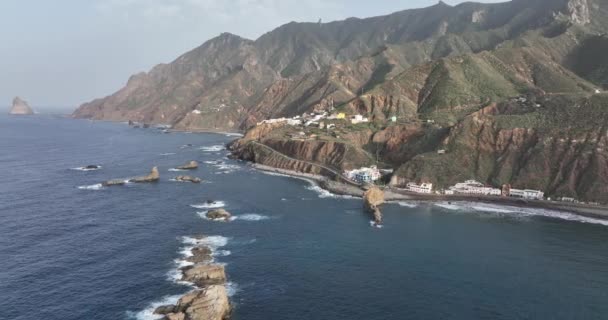 Mała wioska krajobrazowa wzdłuż wybrzeża hiszpańskiego, wybrzeże morskie i wybrzeże na Teneryfie, na wyspie kanaryjskiej. Przegląd panoramiczny dronów lotniczych. Miejscowość turystyczna wzdłuż oceanu. — Wideo stockowe