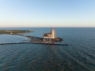 Hollanda 'daki Marken adasının kıyısındaki Paard van Marken' in gündoğumunda gökyüzü manzaralı geleneksel tarihi eser deniz feneri. Avrupa 'da küçük bir balıkçı köyü.