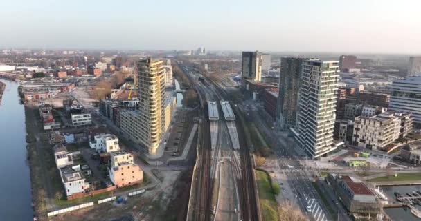 Verdomde Amstel stedenbouwkundige drone view transport en stedelijke residentiële bouwtorens. Infrastructuur station zakelijke gebouwen en skyline. Waterkanaal. — Stockvideo