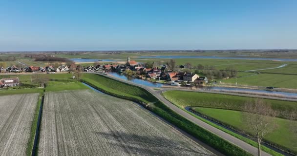 Malá historická typická holandská polder farmářská vesnice v zelené krajině slunné jarní krajiny s vodními cestami a kanály. Zemědělství a travní půda. — Stock video