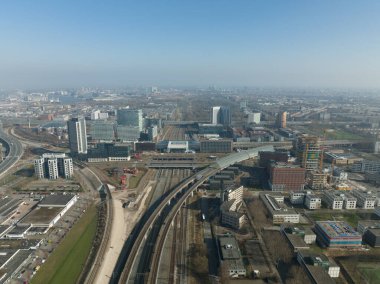 Amsterdam Sloterdijk, Hollanda 'daki tren istasyonu ulaşım altyapısı metro istasyonu. Anayol kentsel geçiş platformu ve ofis binaları silueti.
