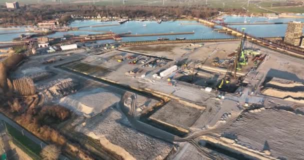 Bouwplaats van een woonwijk nieuwbouw woonwijk stadsgebouwen ontwikkeling site. Stadsplanning en vroege stadia van de bouw. Luchtdrone zicht bij zonsondergang — Stockvideo