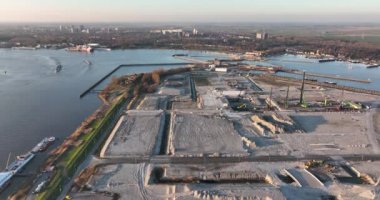 Yaşayan şehir binalarının inşa edildiği yeni bir yerleşim alanının inşaatı. Şehir planlaması ve inşaatın ilk aşamaları. Gün batımında hava aracı görüntüsü