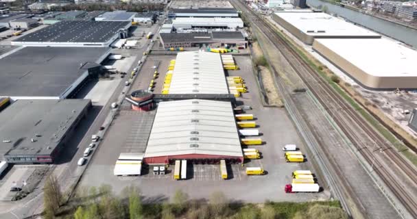 Utrecht, 3 april 2022, Belanda. DHL pengiriman dan distribusi gudang kemasan dengan truk pengiriman dan van bangunan perusahaan. Tampilan drone udara — Stok Video