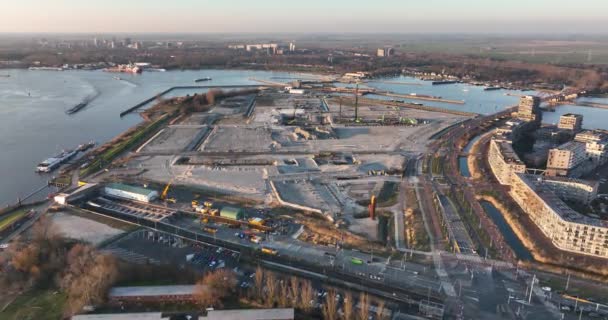 Byggeplads for et beboelsesområde nyopført beboelsesejendom i byområder. Byplanlægning og tidlige stadier af byggeriet. Luftdrone udsigt ved solnedgang – Stock-video