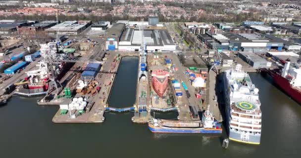 Amszterdam, 2022. március 19, Hollandia. Damen hajójavítás tengerészeti dokkoló hajógyár tengeri karbantartás hajógyártás javítás ipari kikötő. Légi drónra néző. — Stock videók