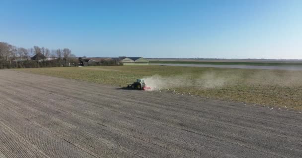 Землеробство трактора оранки фермером в тракторі в весняний сезон. Повітряний дрон оглядає працівника, який обробляє поля і ґрунтові угіддя в Нідерландах.. — стокове відео