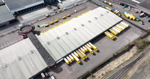 Utrecht, 3 de abril de 2022, Países Bajos. DHL almacén de embalaje de entrega y distribución con camiones de reparto y furgonetas edificio de la empresa. Vista aérea del dron — Vídeo de stock