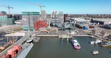 Amsterdam, 19 Mart 2022, Hollanda 'da. NDSM feribotu modern sanayi tersanesine ve son moda yerleşim alanına geliyor. Toplu taşıma yolcularının GVB Ijveer gelişi hava aracı görüntüsü.